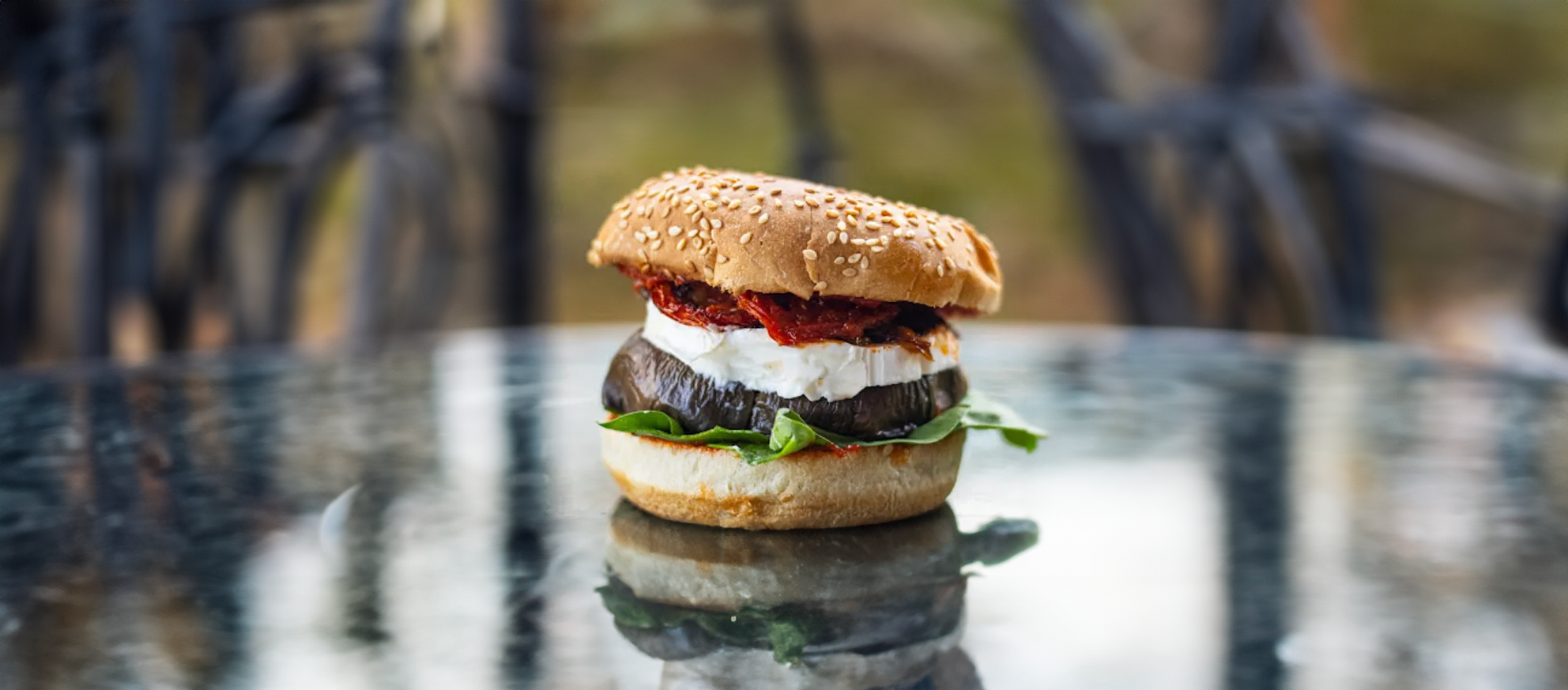 Burger à l'ail noir, aubergine à l'huile, tomates séchées au soleil, fromage de chèvre, courgettes, poivrons, pignons de pain, basilic
